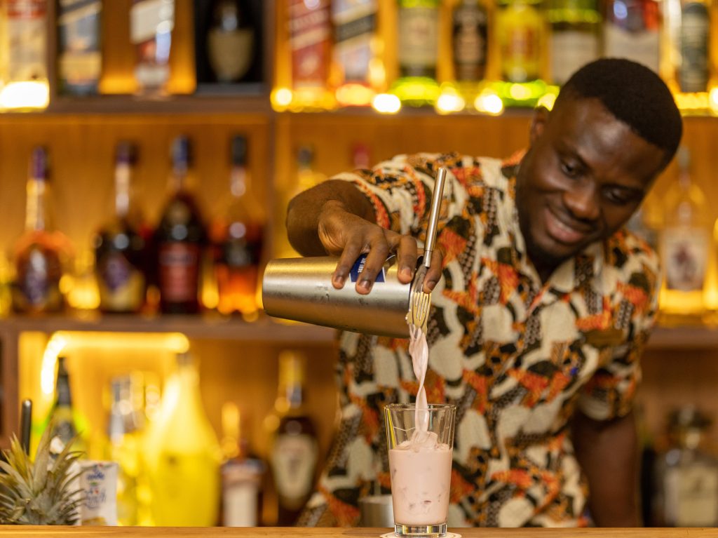 A photo of one of our barman at The Palm Lounge serving a cocktail at The Royal Senchi Hotel & Resort in Ghana
