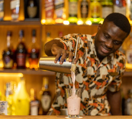 A photo of one of our barman at The Palm Lounge serving a cocktail at The Royal Senchi Hotel & Resort in Ghana