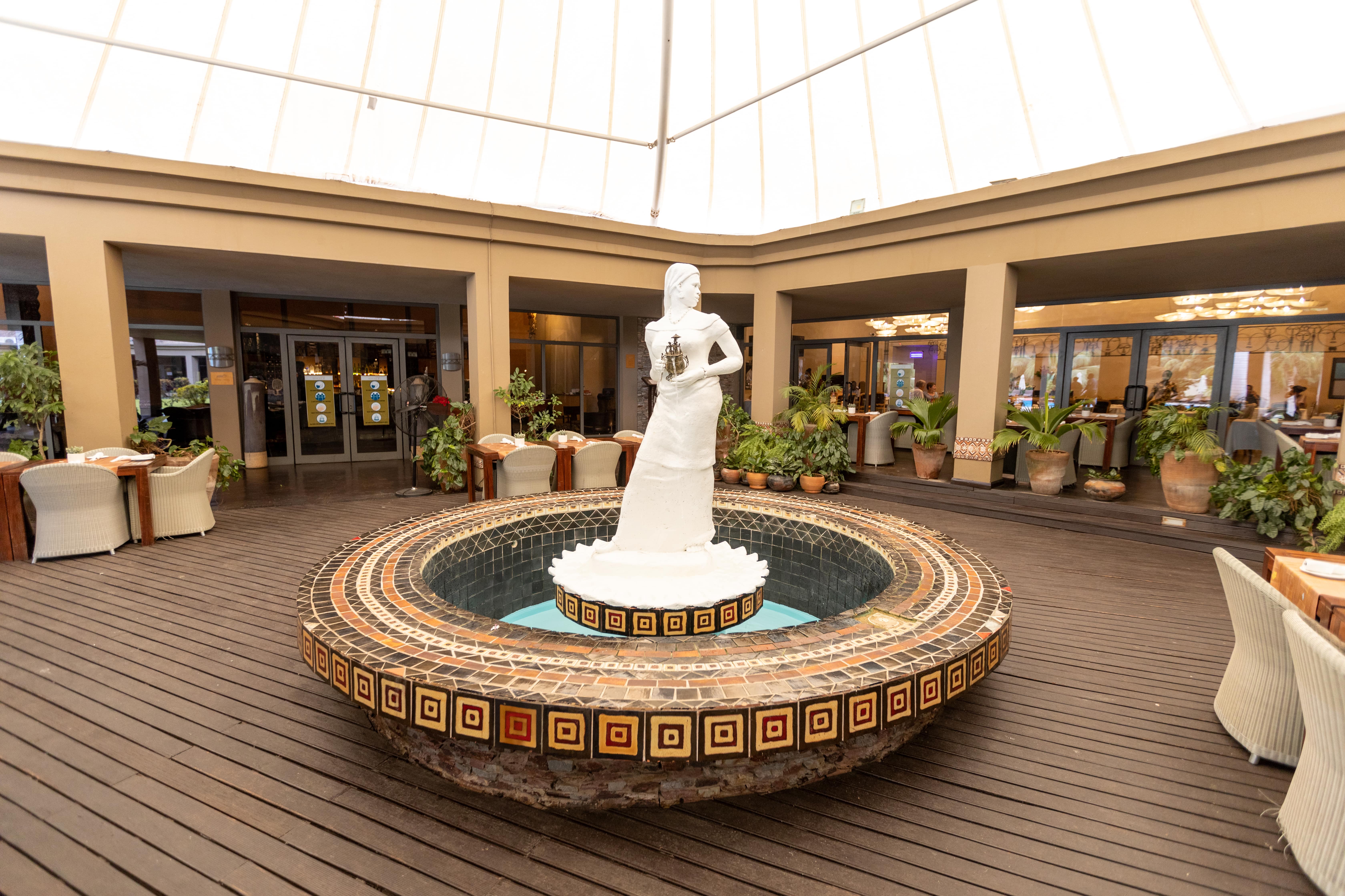 An image of the beautiful fountain and the seating and table set-up for a la carte and buffet international meals at The Senchi Restaurant at The Royal Senchi Hotel & Resort in Ghana