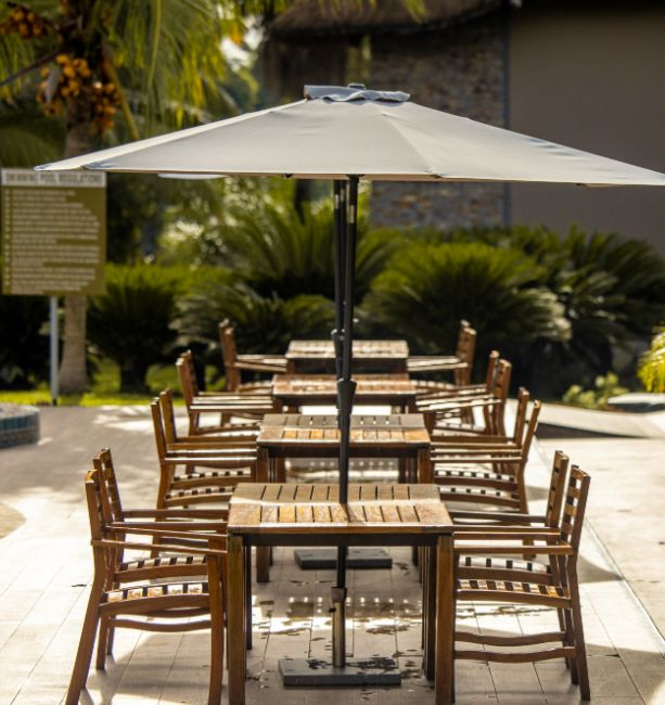 Image of the seating area with umbrellas near the main pool at The Royal Senchi Hotel & Resort in Ghana