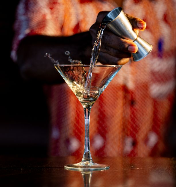 A close-up photo of one of our barman at The Palm Lounge serving a martini at The Royal Senchi Hotel & Resort in Ghana