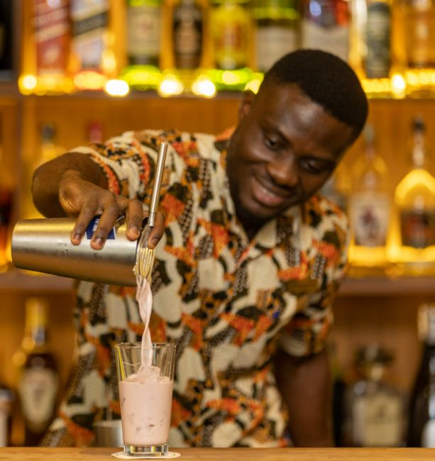 A photo of one of our barman at The Palm Lounge serving a cocktail at The Royal Senchi Hotel & Resort in Ghana