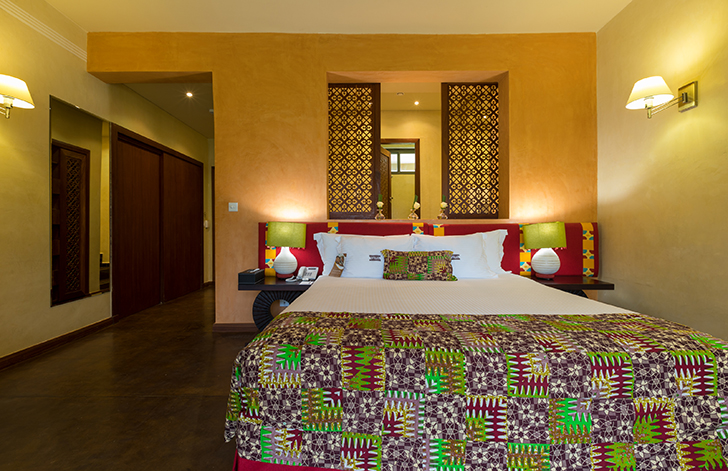 View of the bed in The River View Room at The Royal Senchi Hotel & Resort, Ghana