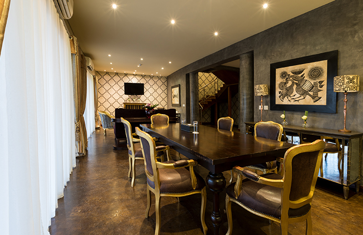 View of the dining area and lounge in The Picathartes Presidential Suite at The Royal Senchi Hotel & Resort, Ghana