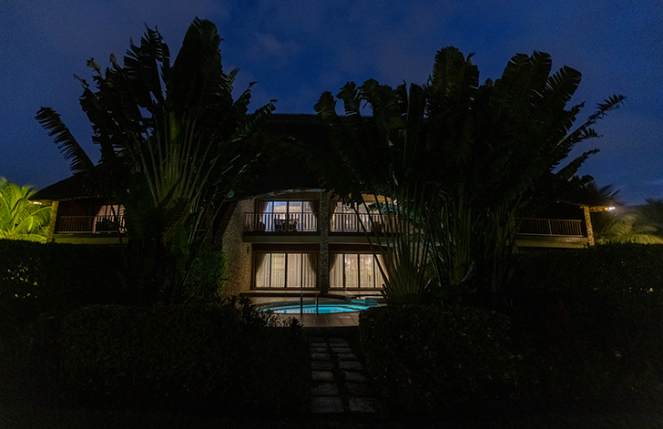 A view of The Picathartes Presidential Suite at night from the exterior at The Royal Senchi Hotel & Resort, Ghana